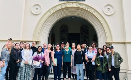UQ students visit places of worship as part of the Studies in Religion course. a group of people stand in the arched entrance to a synagogue